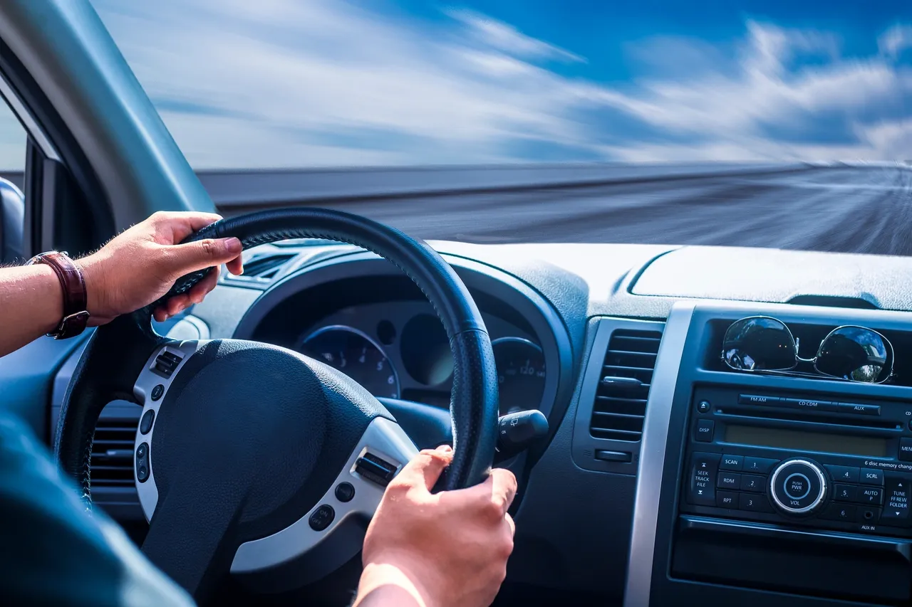 A person driving a car on the highway.